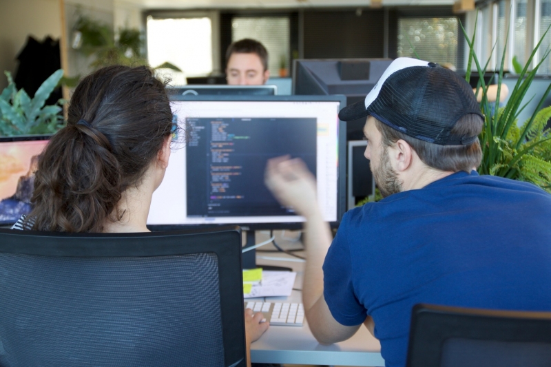 twee ontwikkelaars die naar broncode op een beeldscherm kijken